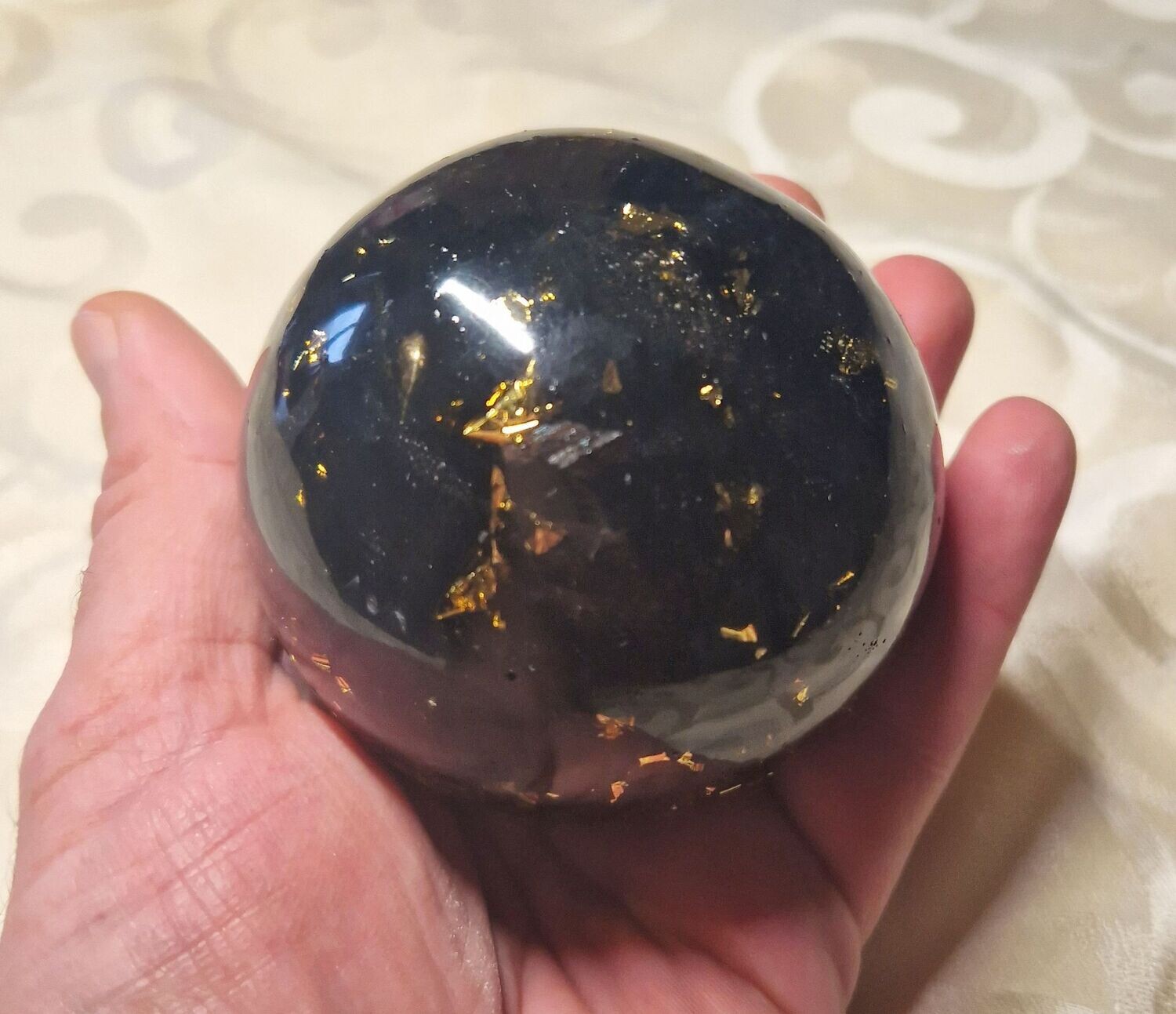 Orgonit Kugel mit schwarzen Turmalin Rohsteinen und goldfarbenem Schlagmetall - ca. 8,5 cm