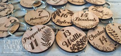 Round wooden veneer keyring with custom engraving, smooth finish, and metal keyring loop."