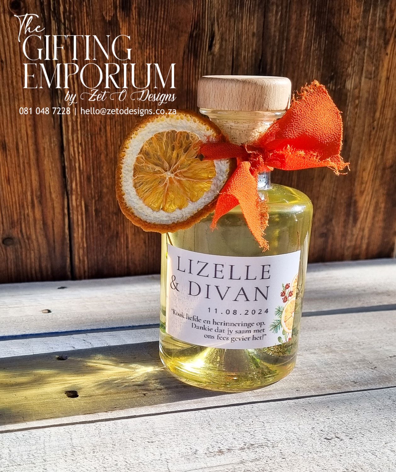 Glass bottle of rosemary-infused olive oil with a "Thank You" tag, placed on a wooden countertop