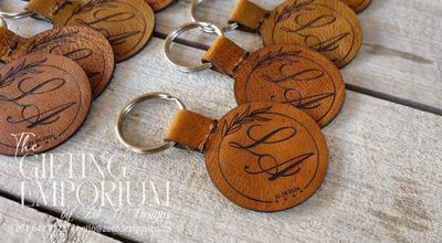 "Round genuine leather keyring with custom motif or emblem engraving, close-up view."
