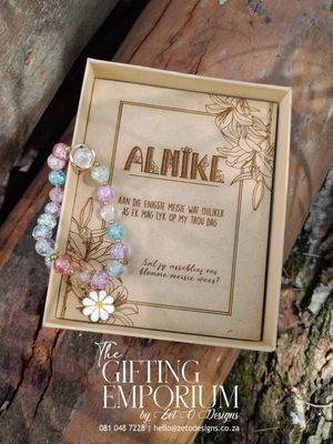 A delicate bracelet with a personalized charm, is elegantly displayed inside a beautifully designed gift box. A flower girl proposal card accompanies the bracelet, making it a heartfelt keepsake gift.