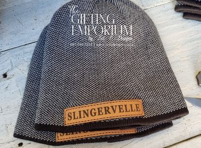 Black rib knit beanie made from water-repellent fabric, featuring a subtle branded logo patch on the front cuff.