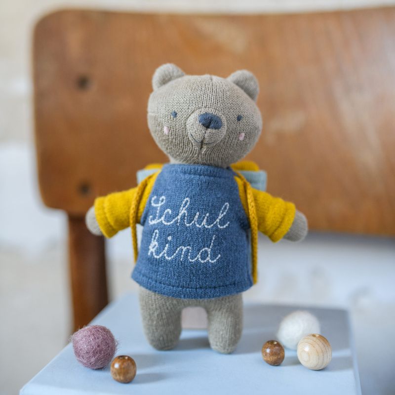 Schulkind” mit Schulranzen und Shirt in blau/gelb