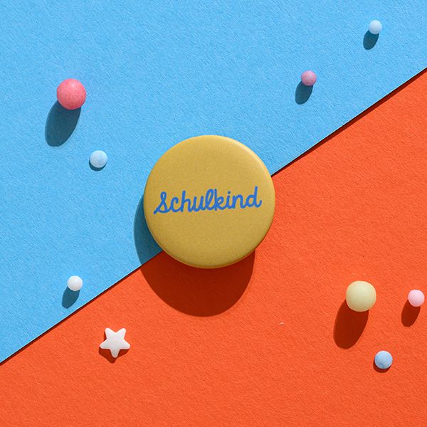 Button „Schulkind“ blau mit Hintergrund senf
