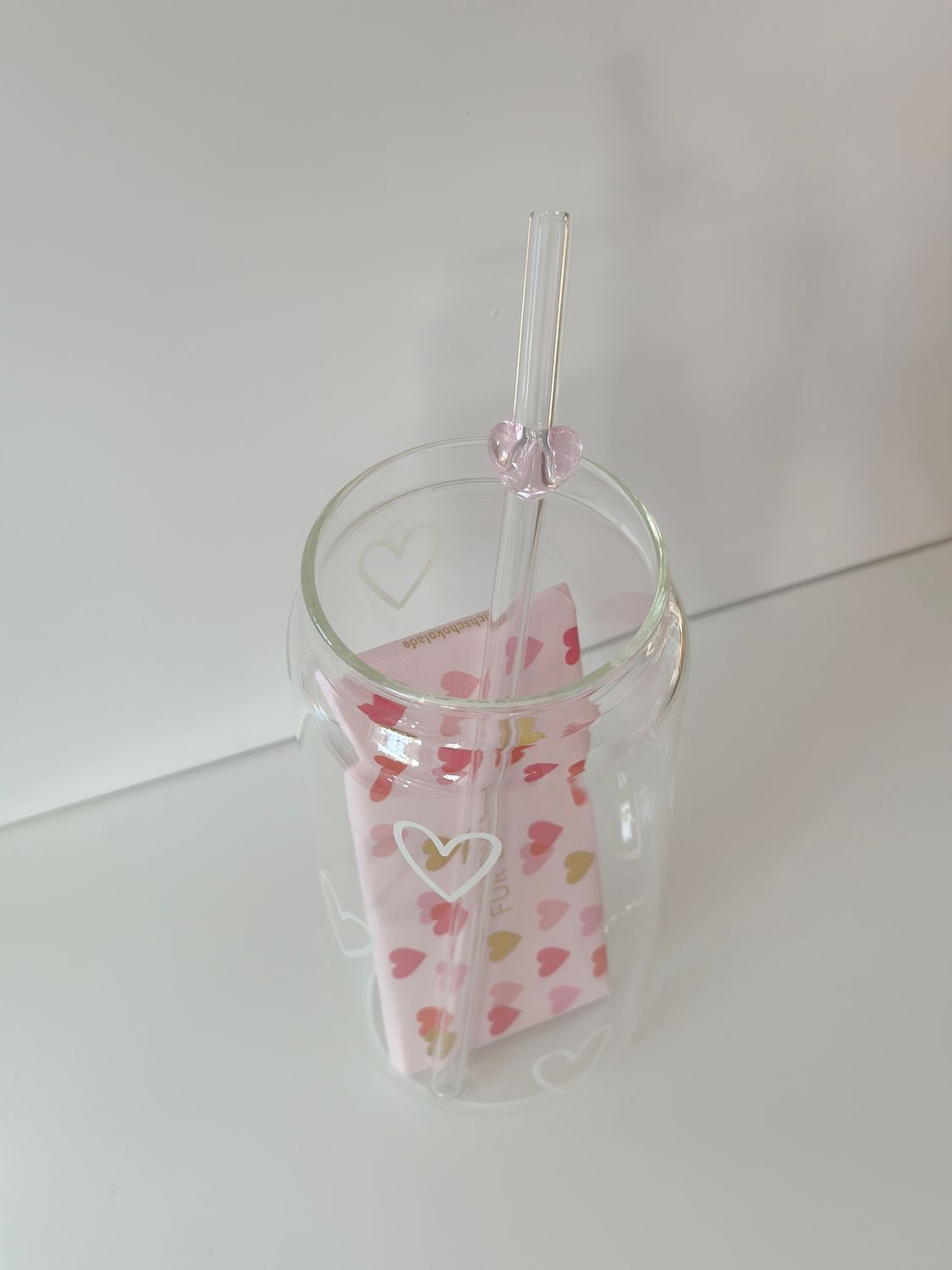 Hohes Trinkglas mit Schoki und Strohhalm