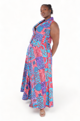 Woman posing in a vibrant, sleeveless patchwork dress featuring red, blue, and purple patterns, exuding confidence and elegance. White background.