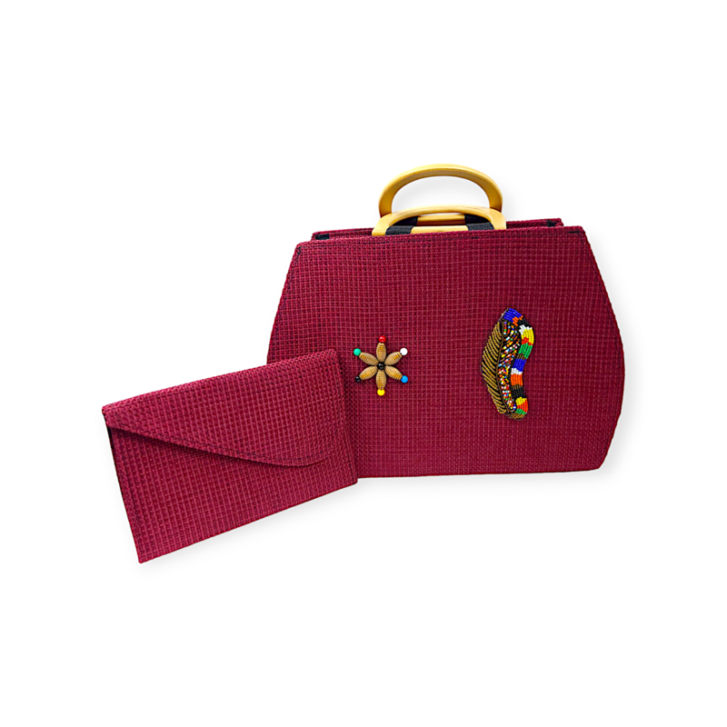 Deep red woven handbag with light wooden handles and colorful beaded designs beside a matching red clutch. Stylish and artistic vibe.