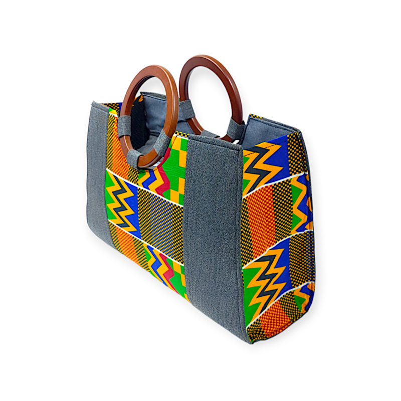 A vibrant handbag features colorful geometric patterns in orange, green, yellow, and blue with wooden handles. The design is both bold and stylish.