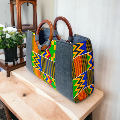 A vibrant handbag features colorful geometric patterns in orange, green, yellow, and blue with wooden handles. The design is both bold and stylish.