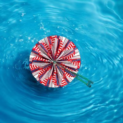 A vibrant circular hand fan with a pattern of red, white, and blue geometric shapes. It has a green handle, evoking a lively and festive tone.