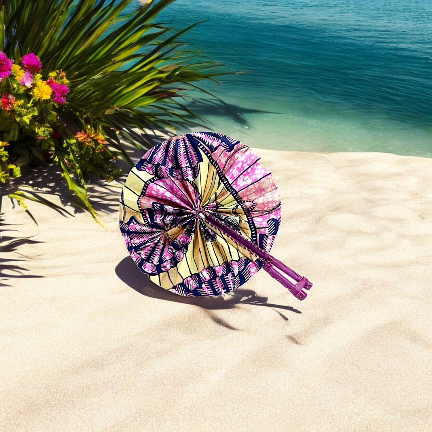 Colorful circular hand fan with intricate patterns in pink, yellow, and navy, featuring dual wooden handles and a vibrant, festive design.