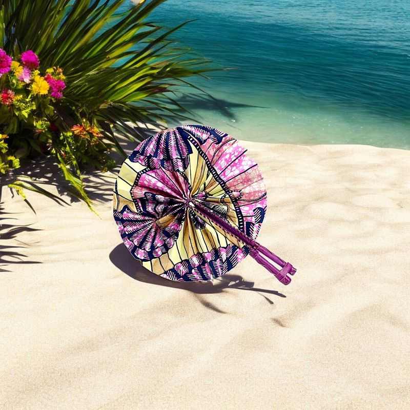 Colorful circular hand fan with intricate patterns in pink, yellow, and navy, featuring dual wooden handles and a vibrant, festive design.
