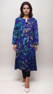 A woman wearing a blue floral print tunic, complemented by a vibrant purple African print kimono.