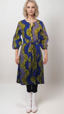 A model showcases a vibrant blue and yellow African print dress, complemented by a stylish blue and gold kimono coat.