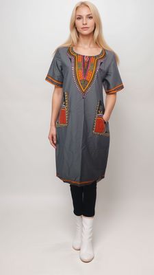 A model displays a stylish grey daishiki shirt dress adorned with bold orange and red patterns.