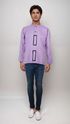 A man in a vibrant purple shirt and casual jeans stands confidently, showcasing a stylish and relaxed look