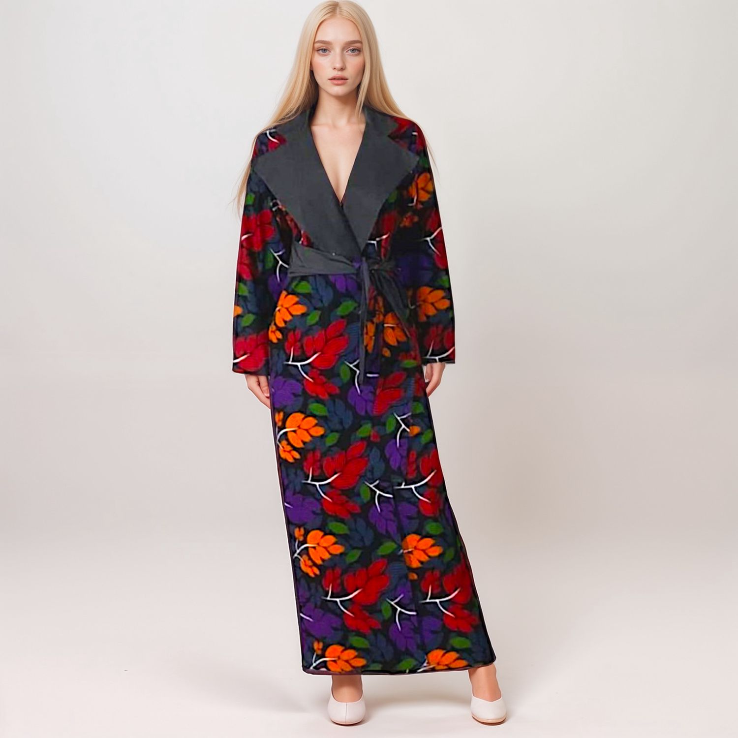 A woman with long blond hair wears a dark, floral-patterned dress with vibrant red, orange, and purple leaves, projecting a calm and elegant tone.