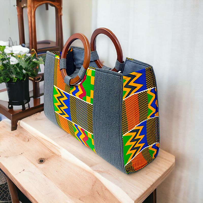 A vibrant handbag features colorful geometric patterns in orange, green, yellow, and blue with wooden handles. The design is both bold and stylish.