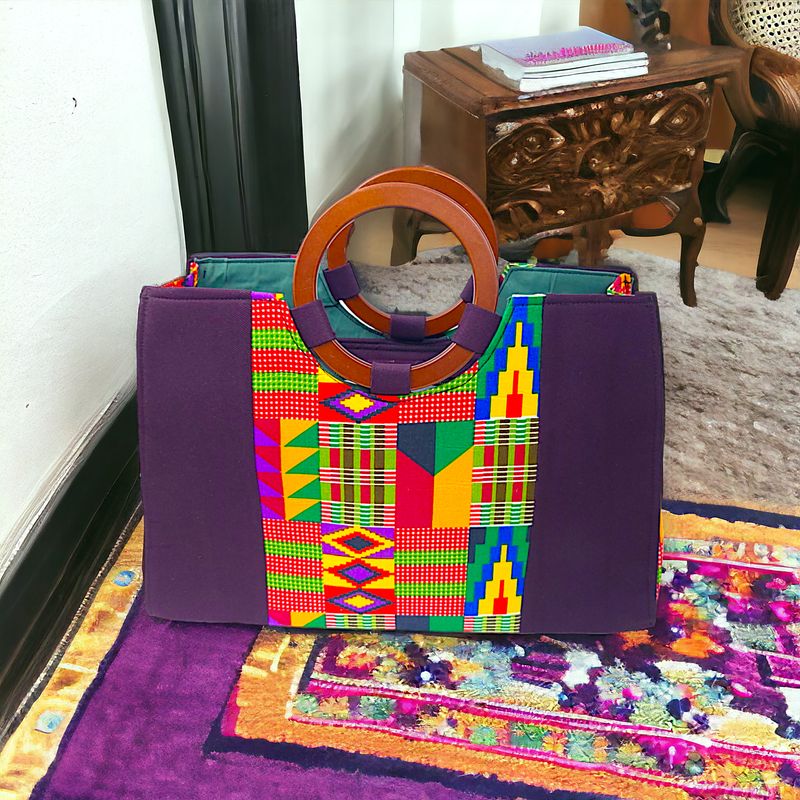 Purple tote bag with vibrant Kente patterns, featuring geometric shapes in red, yellow, green, and blue. Accented with wooden circle handles.