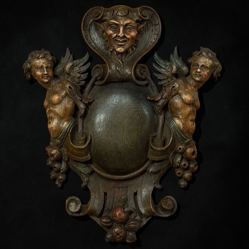 GRANDE CARTIGLIO DECORATIVO IN LEGNO INTAGLIATO CON PUTTI ALATI E MASCHERA DI FAUNO, XIX SECOLO GRANDE CARTIGLIO DECORATIVO IN LEGNO INTAGLIATO CON PUTTI ALATI E MASCHERA DI FAUNO, XIX SECOLO