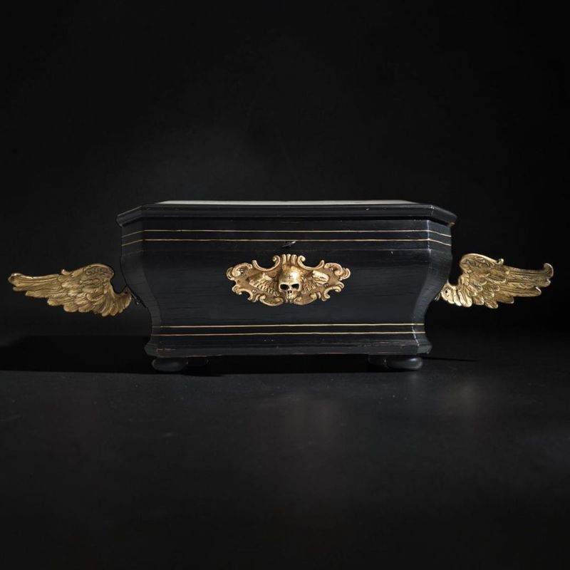 Urna funeraria alata in legno ebanizzato, bronzo dorato e Memento Mori – XIX secolo Urna funeraria alata in legno ebanizzato, bronzo dorato e Memento Mori – XIX secolo