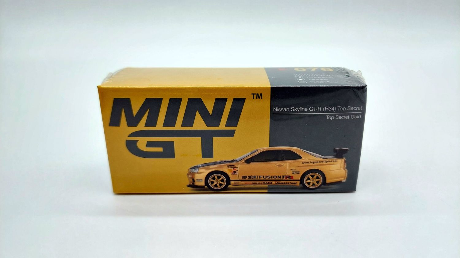 #676 MINI GT Nissan Skyline GT-R (R34) Top Secret Gold
