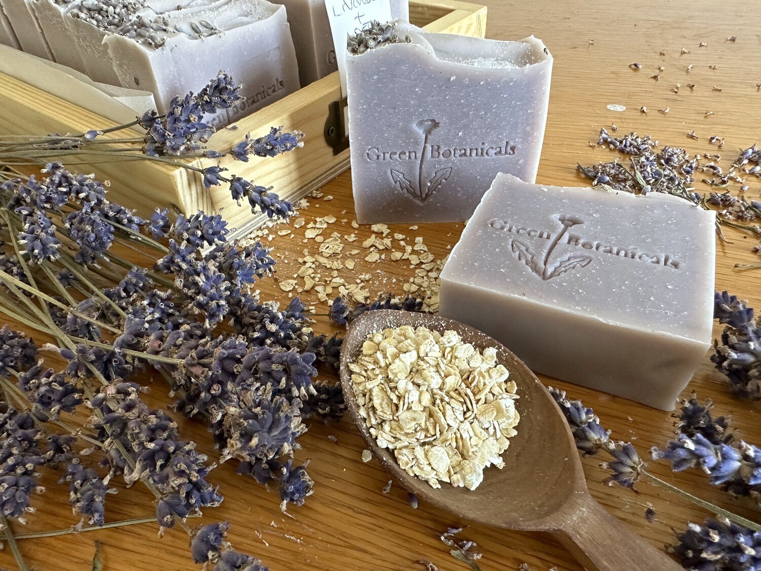 A bar of natural lavender and oatmeal soap with visible lavender flower petals, oatmeal and a calming purple colour