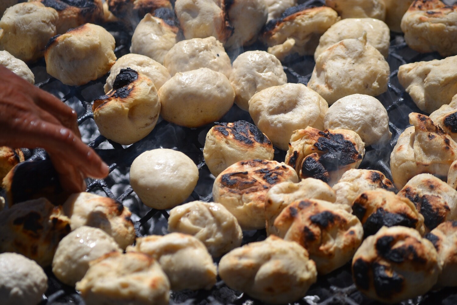 Auf Holzkohle gegrillte, hausgemachte frische Broetchen. Langebaan, Suedafrika.
