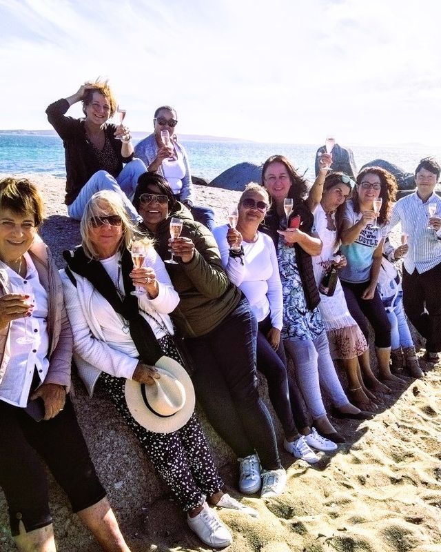 Ein Bild einer Gruppe von 12 Personen dierekt an der Kueste mit Wind in den Haaren und einem Glas in der Hand.
Im Hntergrund das Meer. Im Vordergrund Sand.

Langebaan, Suedafrika