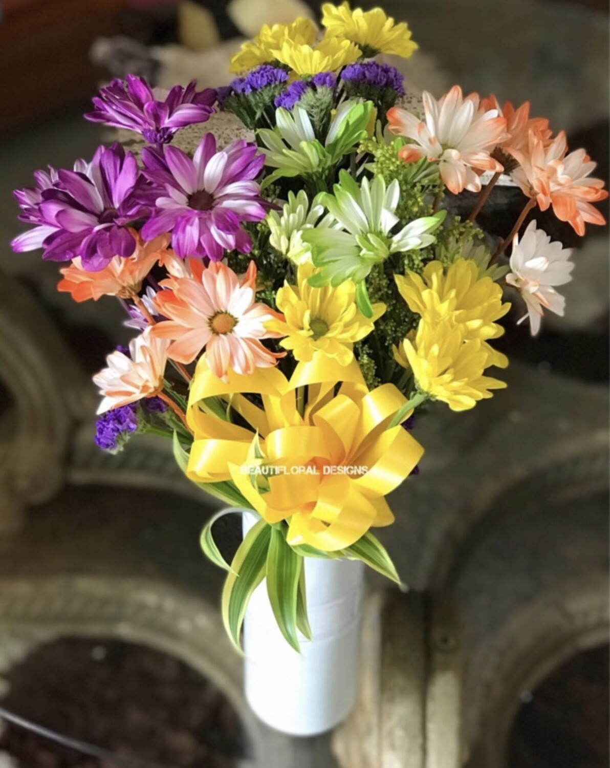 Mixed colored daisies in a vase