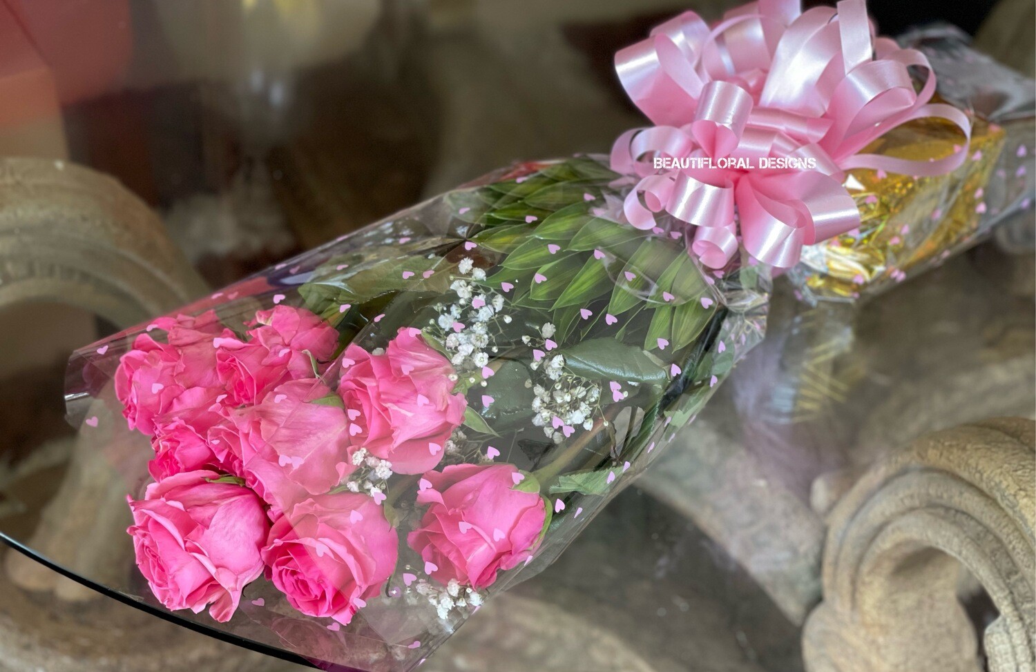 8 pink roses in a sleeve