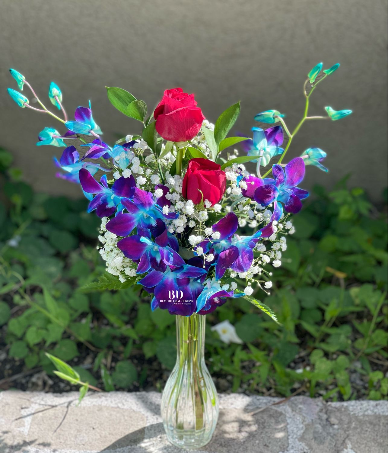 2 blue orchids, 2 red roses in a vase