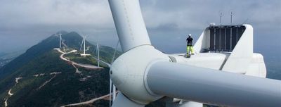 Technician using rope access techniques for safe turbine maintenance.