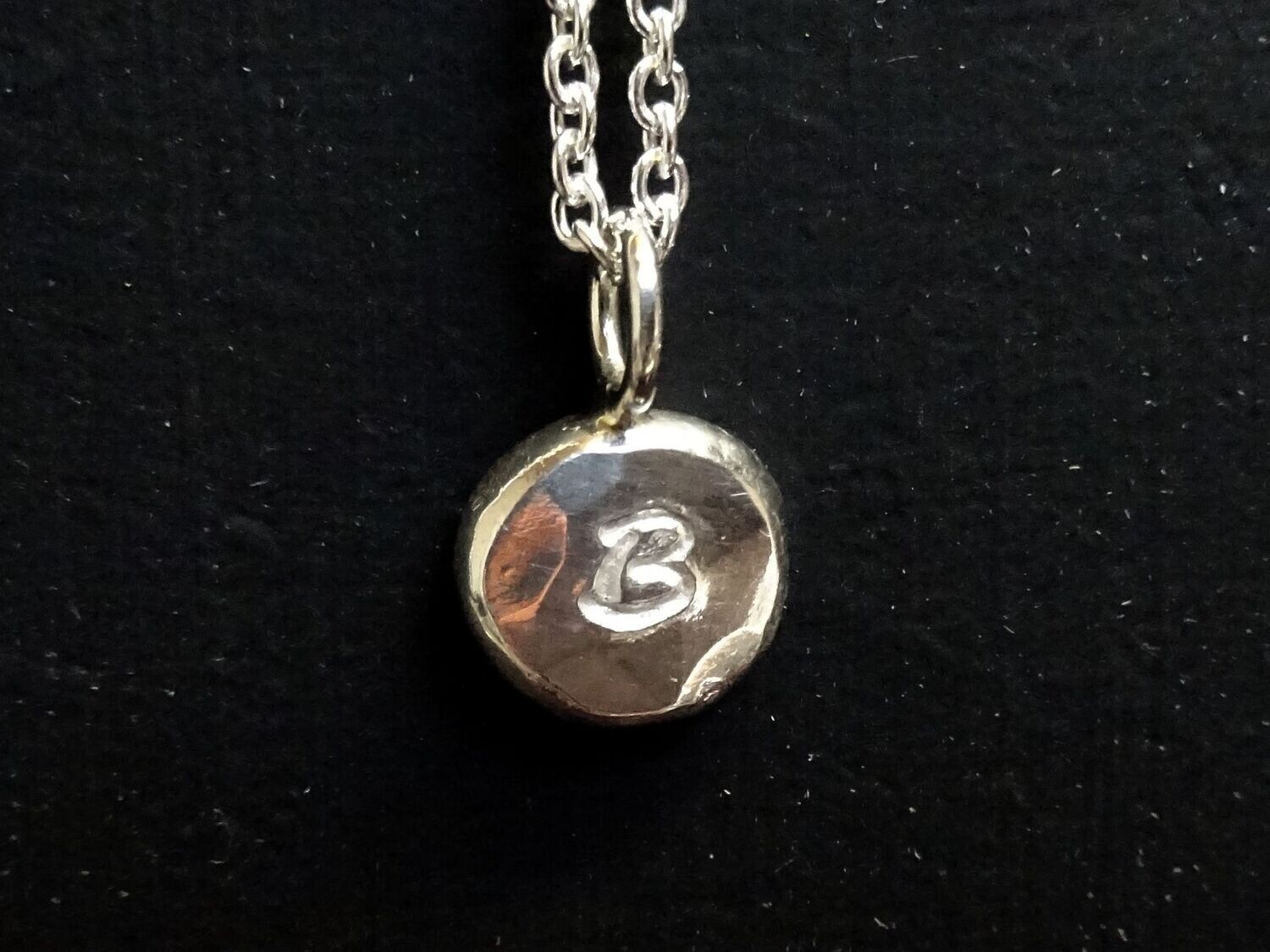 Hangertje van platgeslagen bolletje zilver met letter (3007)