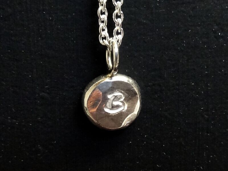 Hangertje van platgeslagen bolletje zilver met letter (3007)