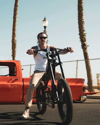 Man on Plum Motorbikes customer chopper style e bike in Huntington Beach California