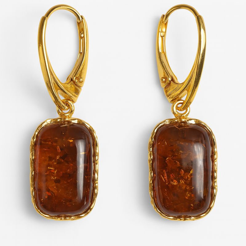 მოოქროვილი საყურე ნატურალური ბალტიური ქარვით — ხელნაკეთი სამკაული Amarta Premium-ის ზაფხულის კოლექციიდან, მოდელის ყურზე ზღვის