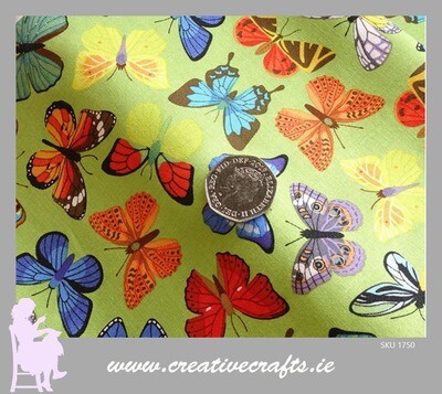 Cotton fabric with multicolored butterflies on a green