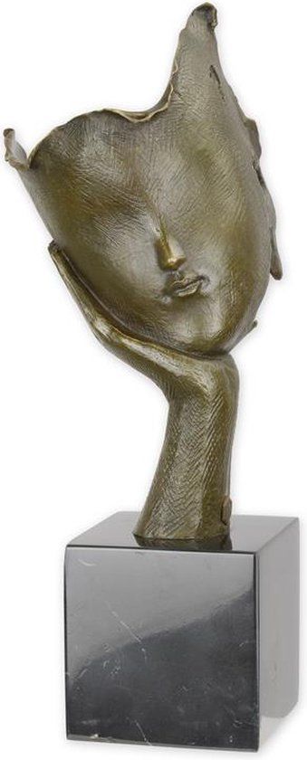 EEN BRONZEN BEELD VAN EEN GEZICHT DAT OP HANDPALM RUST (be-41)