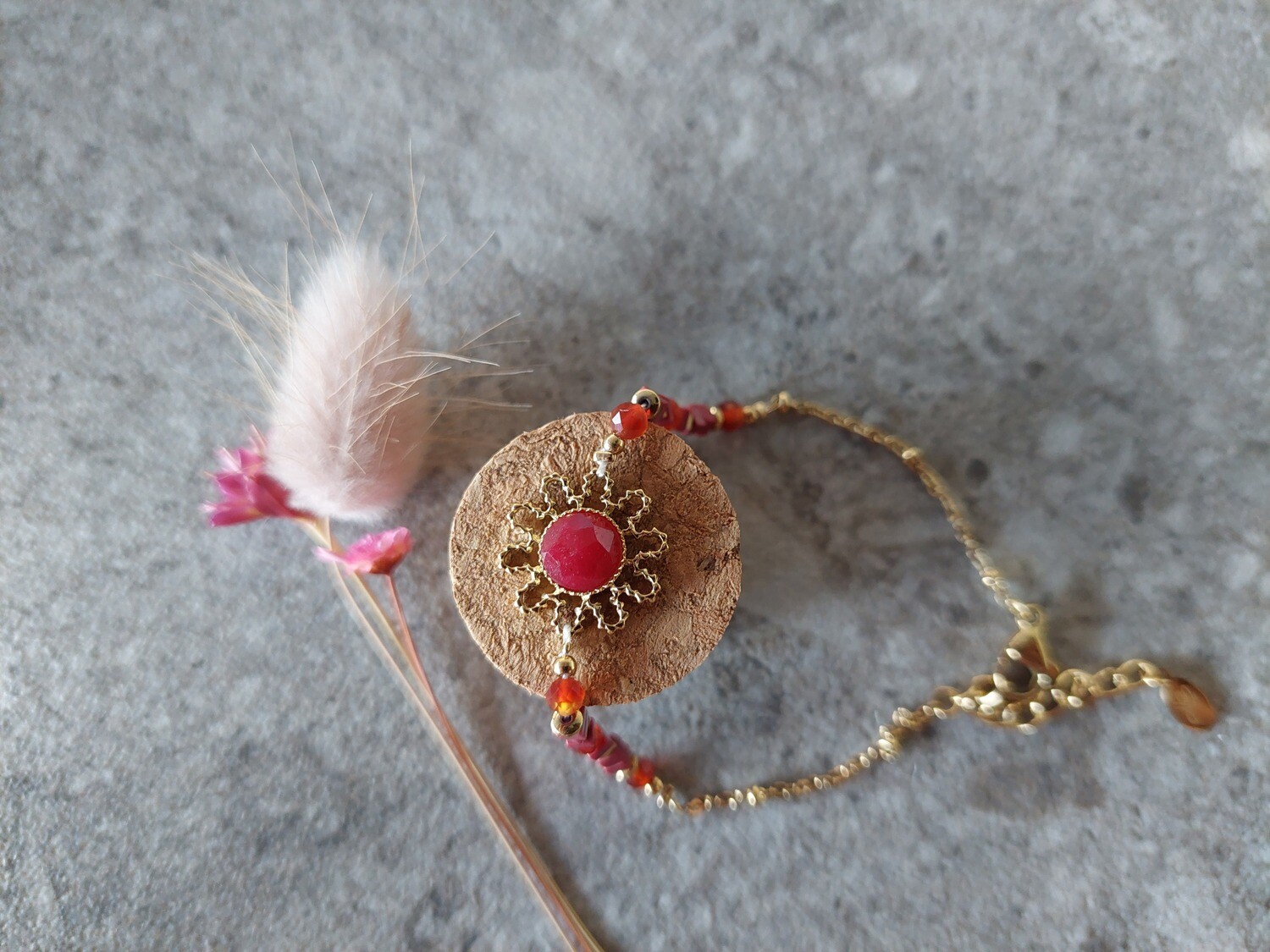 Gouden schakelarmband met accentbloem in kleuren rood en goud
