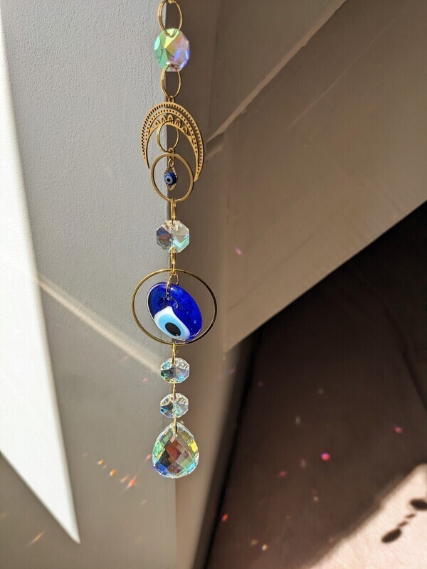 Attrape soleil fait main en pièce unique ou petite série, composé de matériaux durables de qualité.  Nazar en verre tout droit venu d&#39;Istanbul. Objet de décoration Feng Shui, l&#39;attrape soleil, invite à l&#39;intérieur de votre maison toutes les belles énergies du soleil en créant un arc-en-ciel lumineux plein de douceur et de magie. Il réharmonise et protège votre intérieur.