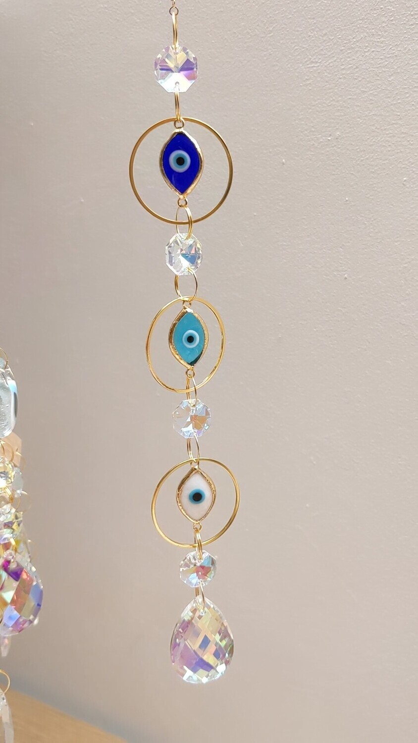 Attrape soleil fait main en pièce unique ou petite série, composé de matériaux durables de qualité.  Nazar en verre tout droit venu d&#39;Istanbul. Objet de décoration Feng Shui, l&#39;attrape soleil, invite à l&#39;intérieur de votre maison toutes les belles énergies du soleil en créant un arc-en-ciel lumineux plein de douceur et de magie. Il réharmonise et protège votre intérieur.