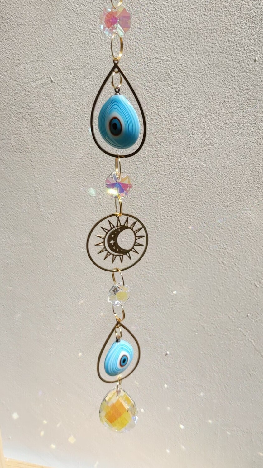 Attrape soleil fait main, composé de matériaux durables de qualité. Nazar en verre tout droit venu d&#39;Istanbul. 
Objet de décoration Feng Shui, l&#39;attrape soleil, invite à l&#39;intérieur de votre maison toutes les belles énergies du soleil en créant un arc-en-ciel lumineux plein de douceur et de magie. Il réharmonise et protège votre intérieur.
