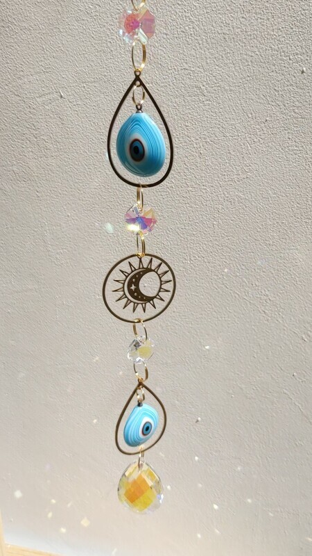 Attrape soleil fait main, composé de matériaux durables de qualité. Nazar en verre tout droit venu d&#39;Istanbul. 
Objet de décoration Feng Shui, l&#39;attrape soleil, invite à l&#39;intérieur de votre maison toutes les belles énergies du soleil en créant un arc-en-ciel lumineux plein de douceur et de magie. Il réharmonise et protège votre intérieur.