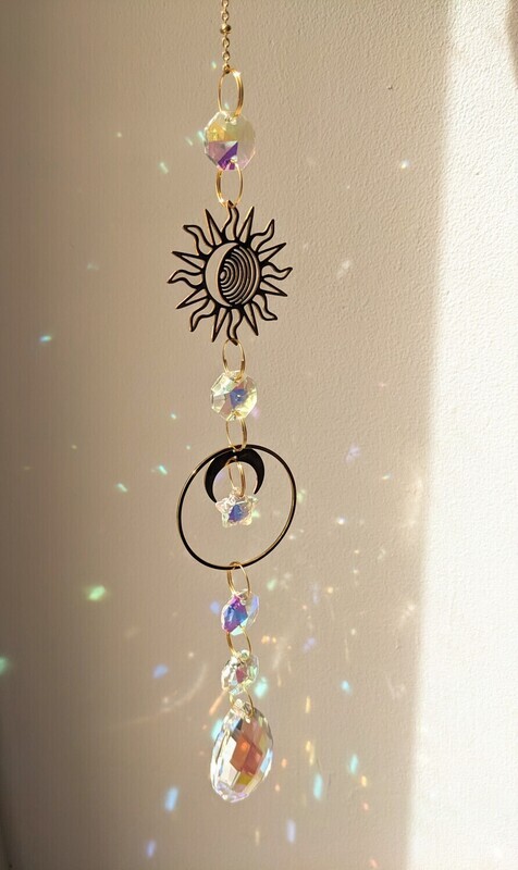 Attrape soleil fait main en pièce unique ou petite série, composé de matériaux durables de qualité. Objet de décoration Feng Shui, l&#39;attrape soleil, invite à l&#39;intérieur de votre maison toutes les belles énergies du soleil en créant un arc-en-ciel lumineux plein de douceur et de magie. Il réharmonise et protège votre intérieur. soleil et lune