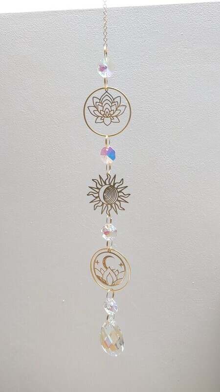 Attrape soleil fait main en pièce unique ou petite série, composé de matériaux durables de qualité. Objet de décoration Feng Shui, l&#39;attrape soleil, invite à l&#39;intérieur de votre maison toutes les belles énergies du soleil en créant un arc-en-ciel lumineux plein de douceur et de magie. Il réharmonise et protège votre intérieur. Fleur de lotus, soleil et lune.