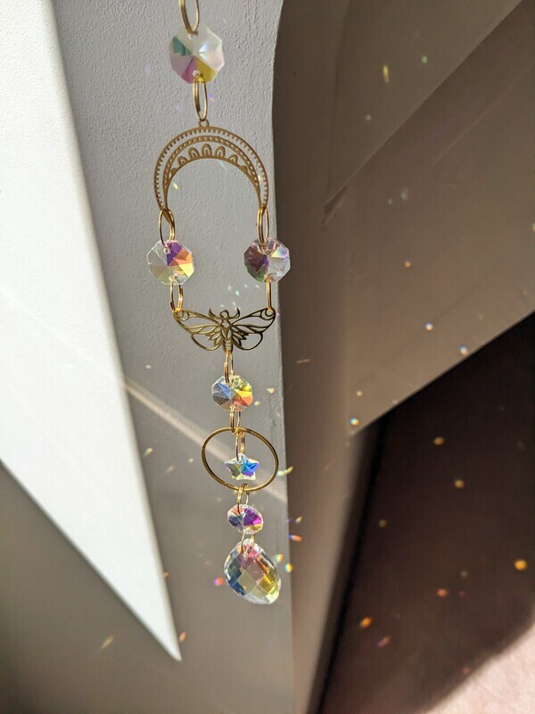 Attrape soleil fait main en pièce unique ou petite série, composé de matériaux durables de qualité. Objet de décoration Feng Shui, l&#39;attrape soleil, invite à l&#39;intérieur de votre maison toutes les belles énergies du soleil en créant un arc-en-ciel lumineux plein de douceur et de magie. Il réharmonise et protège votre intérieur. papillon étoile