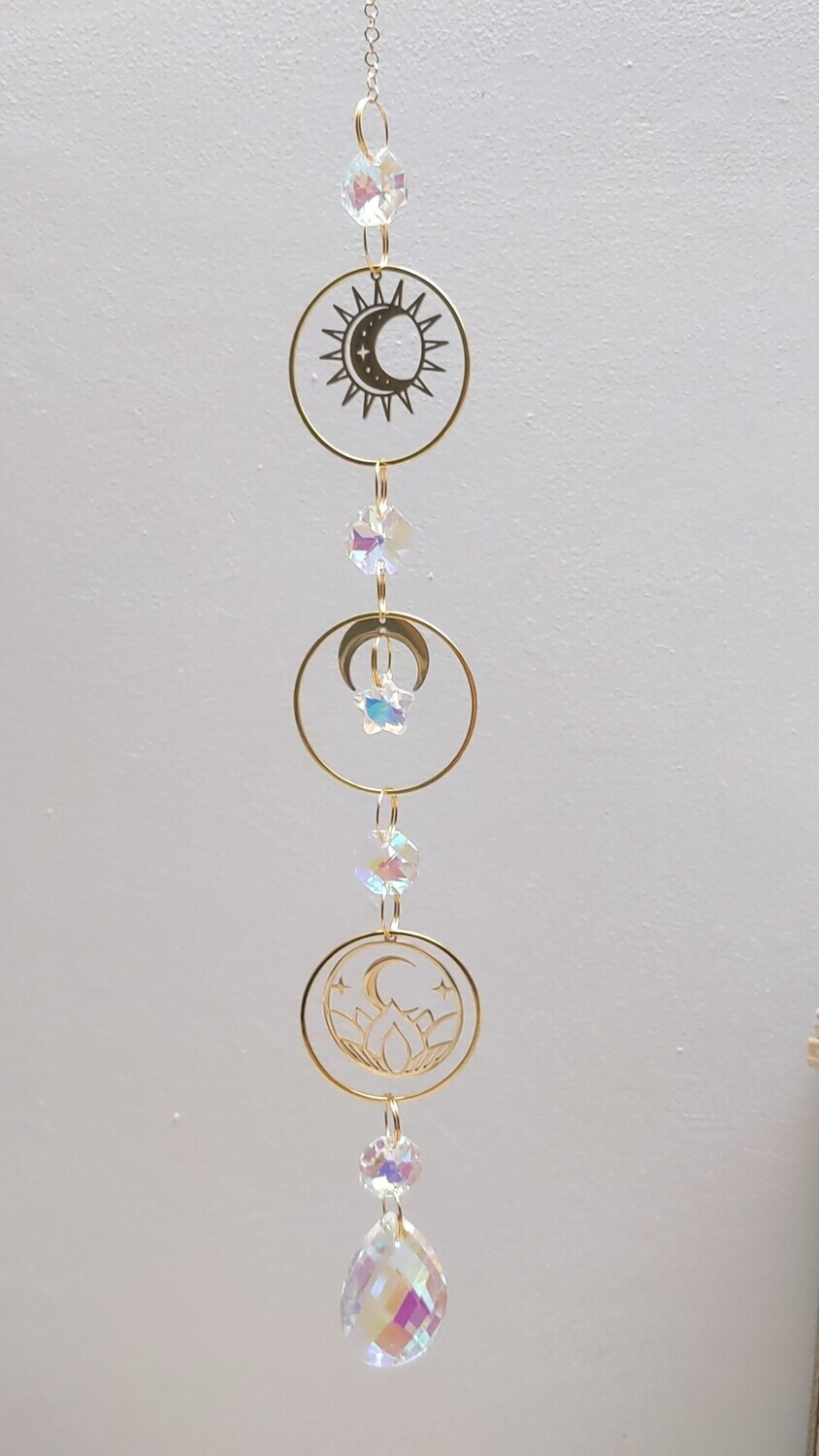 Attrape soleil fait main en pièce unique ou petite série, composé de matériaux durables de qualité. Objet de décoration Feng Shui, l&#39;attrape soleil, invite à l&#39;intérieur de votre maison toutes les belles énergies du soleil en créant un arc-en-ciel lumineux plein de douceur et de magie. Il réharmonise et protège votre intérieur. soleil, lune, lotus