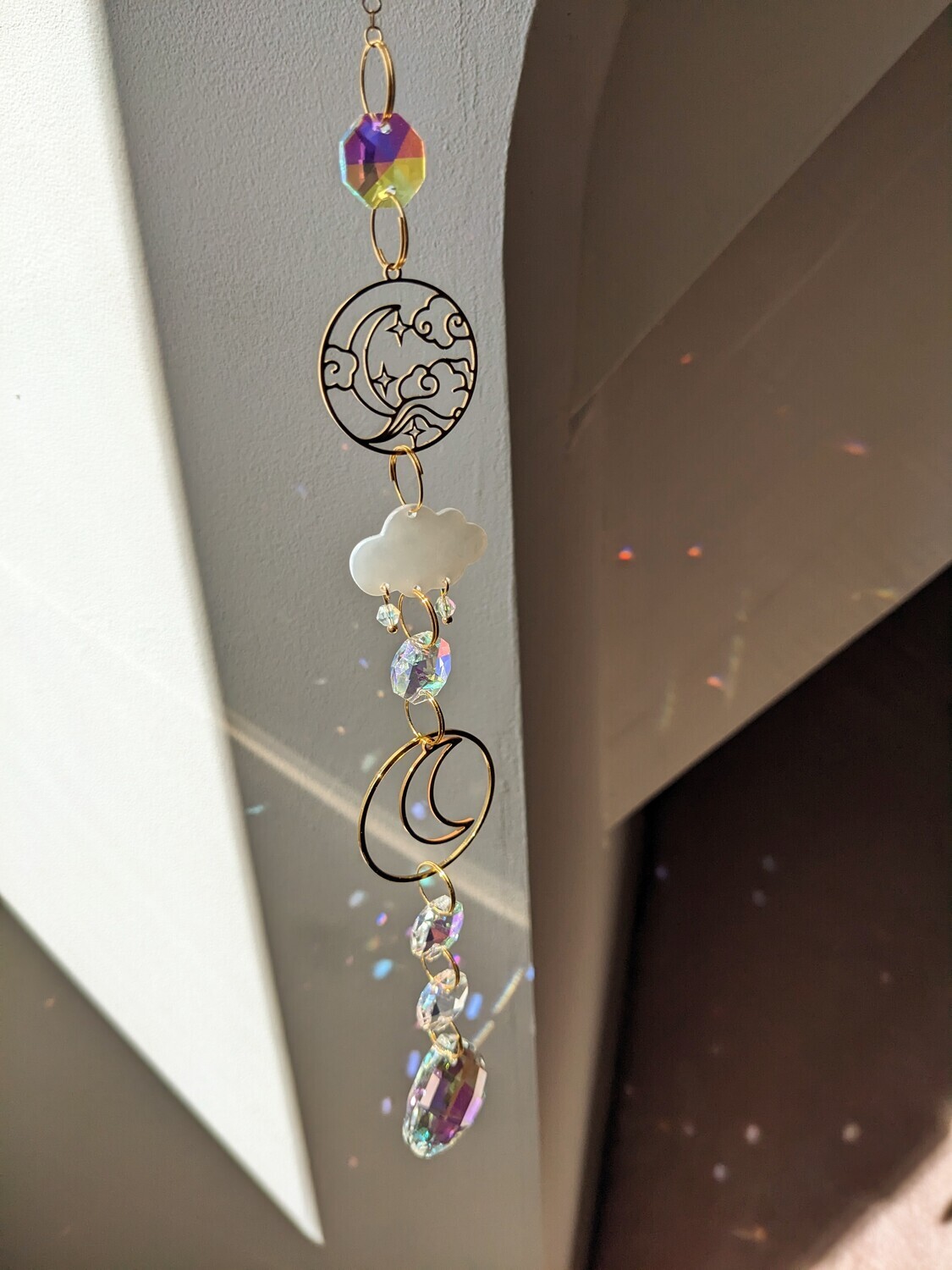 Attrape soleil fait main en pièce unique ou petite série, composé de matériaux durables de qualité. Objet de décoration Feng Shui, l&#39;attrape soleil, invite à l&#39;intérieur de votre maison toutes les belles énergies du soleil en créant un arc-en-ciel lumineux plein de douceur et de magie. Il réharmonise et protège votre intérieur. nuage et lune