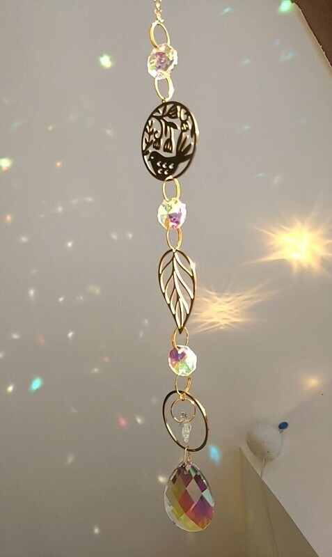 Attrape soleil fait main en pièce unique ou petite série, composé de matériaux durables de qualité. Objet de décoration Feng Shui, l&#39;attrape soleil, invite à l&#39;intérieur de votre maison toutes les belles énergies du soleil en créant un arc-en-ciel lumineux plein de douceur et de magie. Il réharmonise et protège votre intérieur. oiseau et feuille